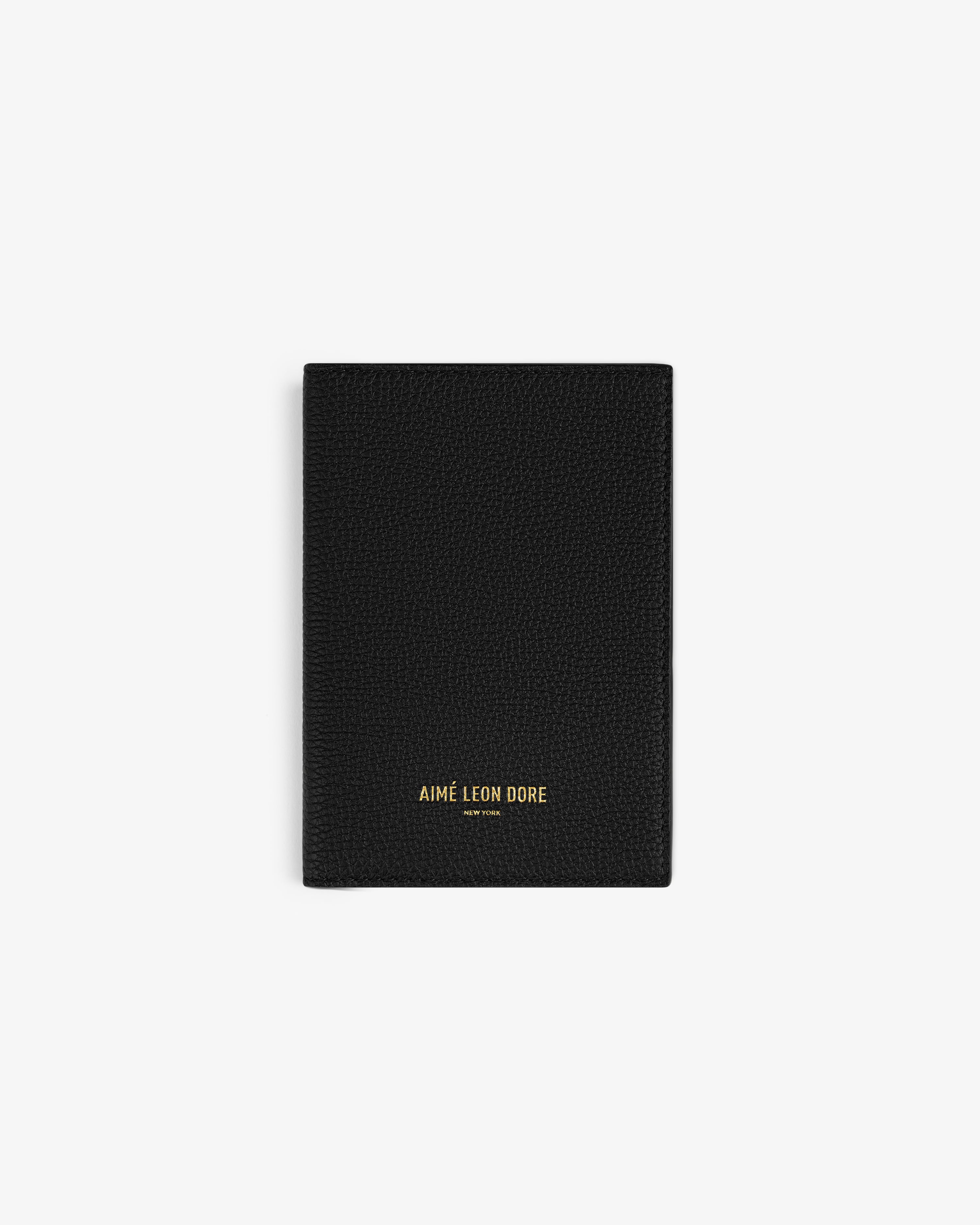 A black Leather Passport Holder with AIMÉ LEON DORE in gold at the bottom center.