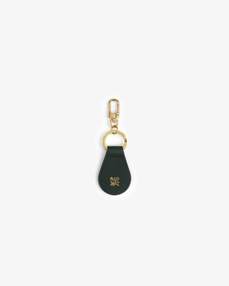 Leather Key Fob in dark green with gold hardware and a small gold flower emblem on the leather.