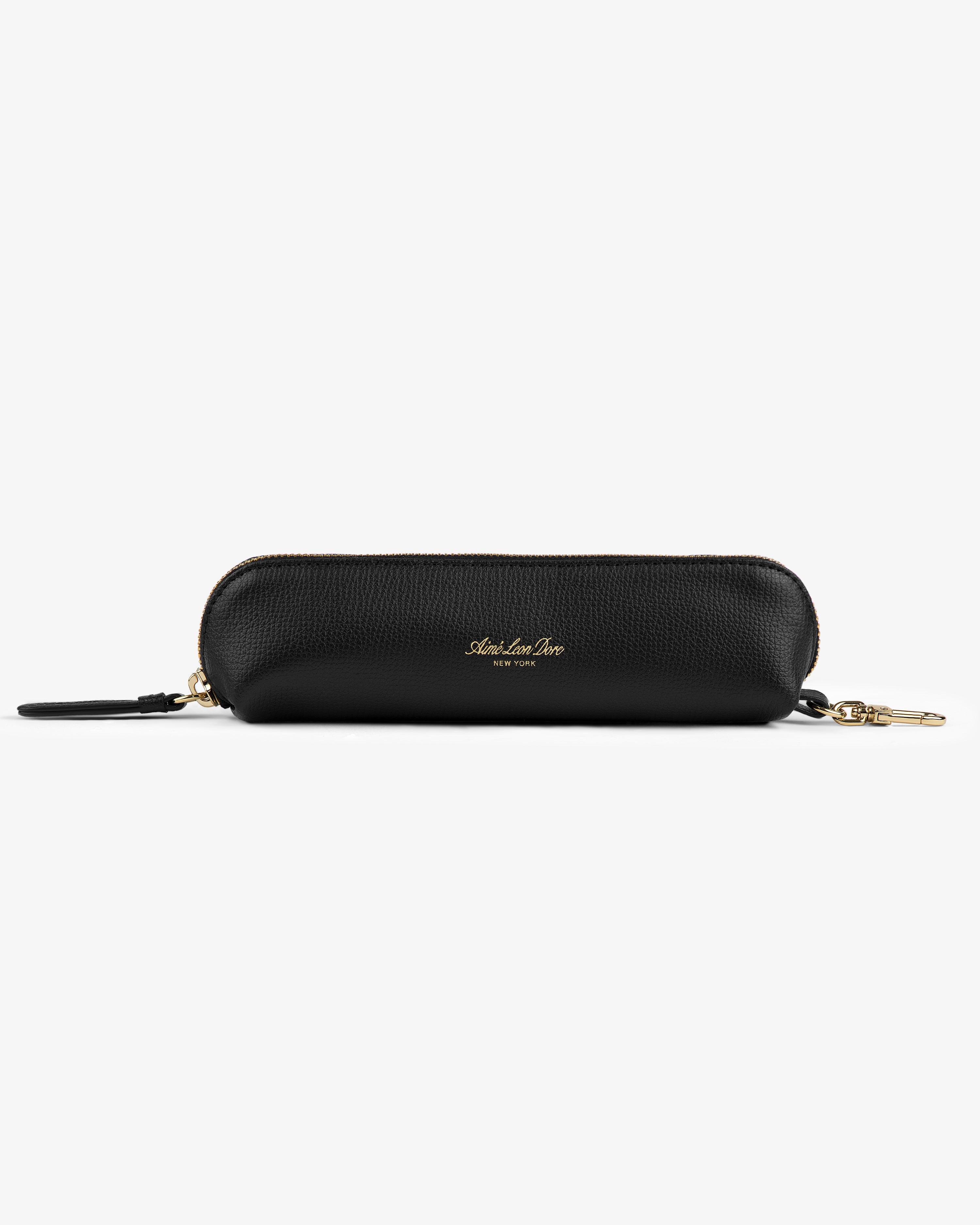 The Leather Pencil Case is black with textured leather, a zipper, and a gold clasp, shown on a white background.