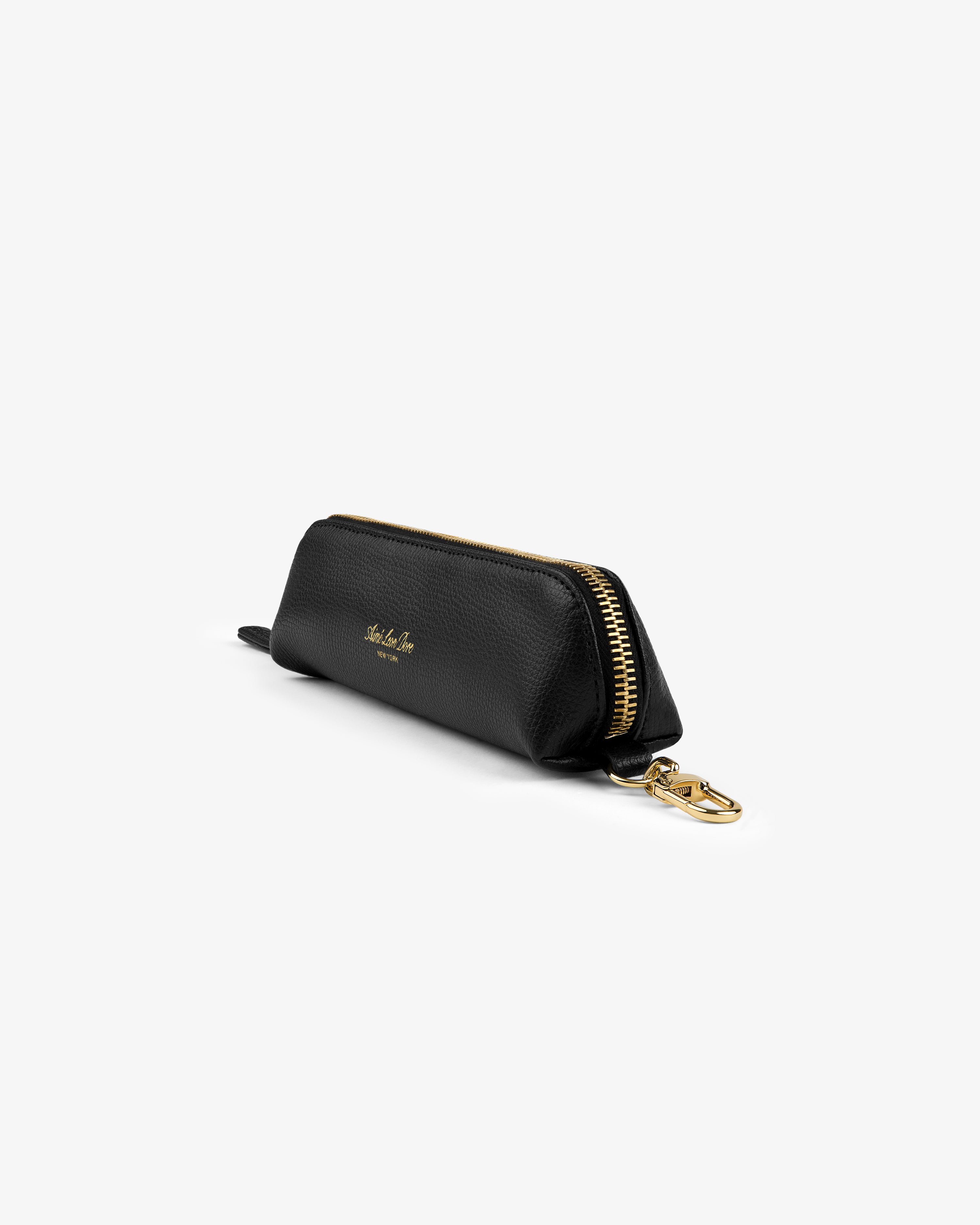 Leather Pencil Case in black with gold zipper, clasp, and small gold side text, shown on a white background.