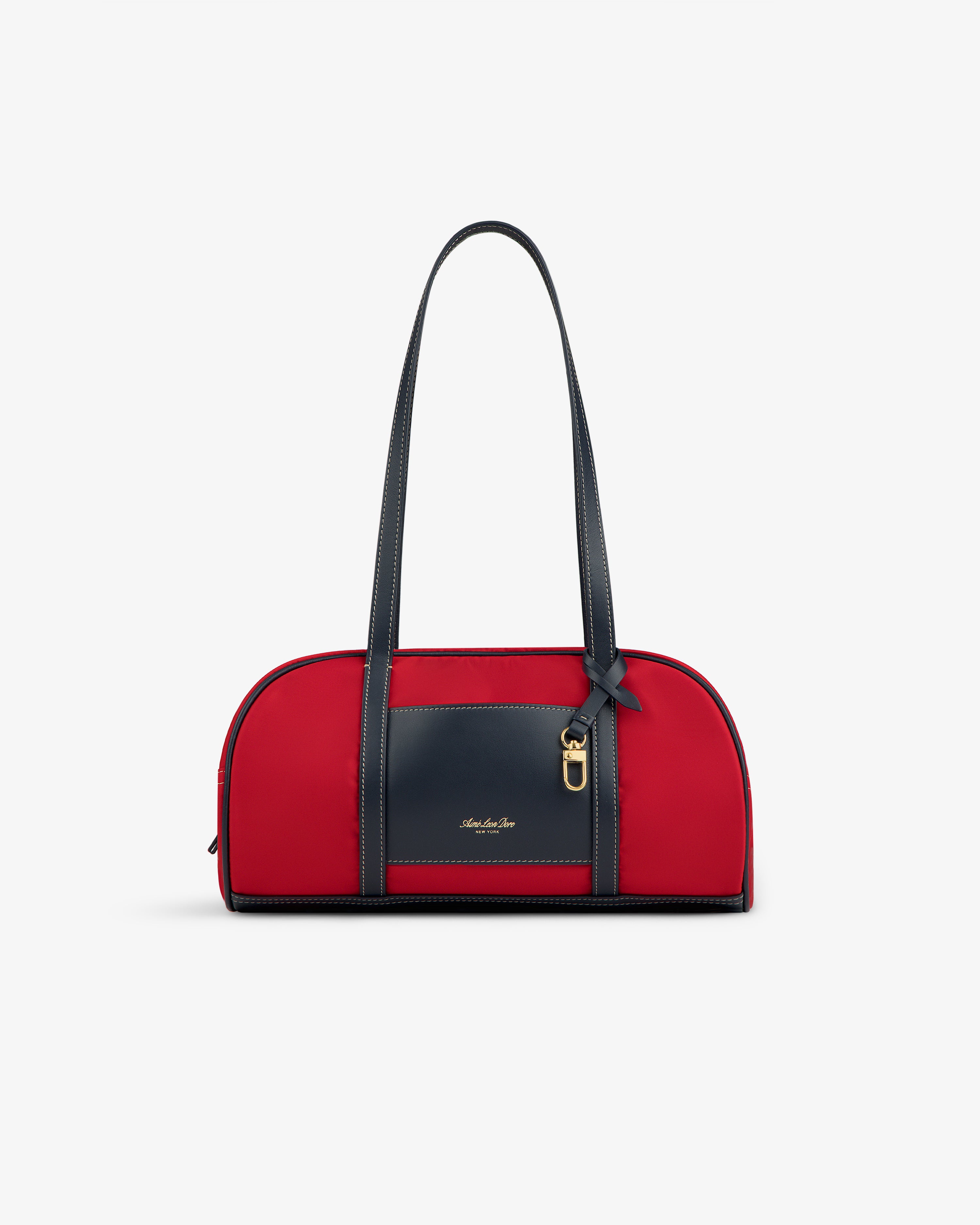 Mini Duffle Shoulder Bag in red with long black handles, a black front pocket, and gold accent on white background.