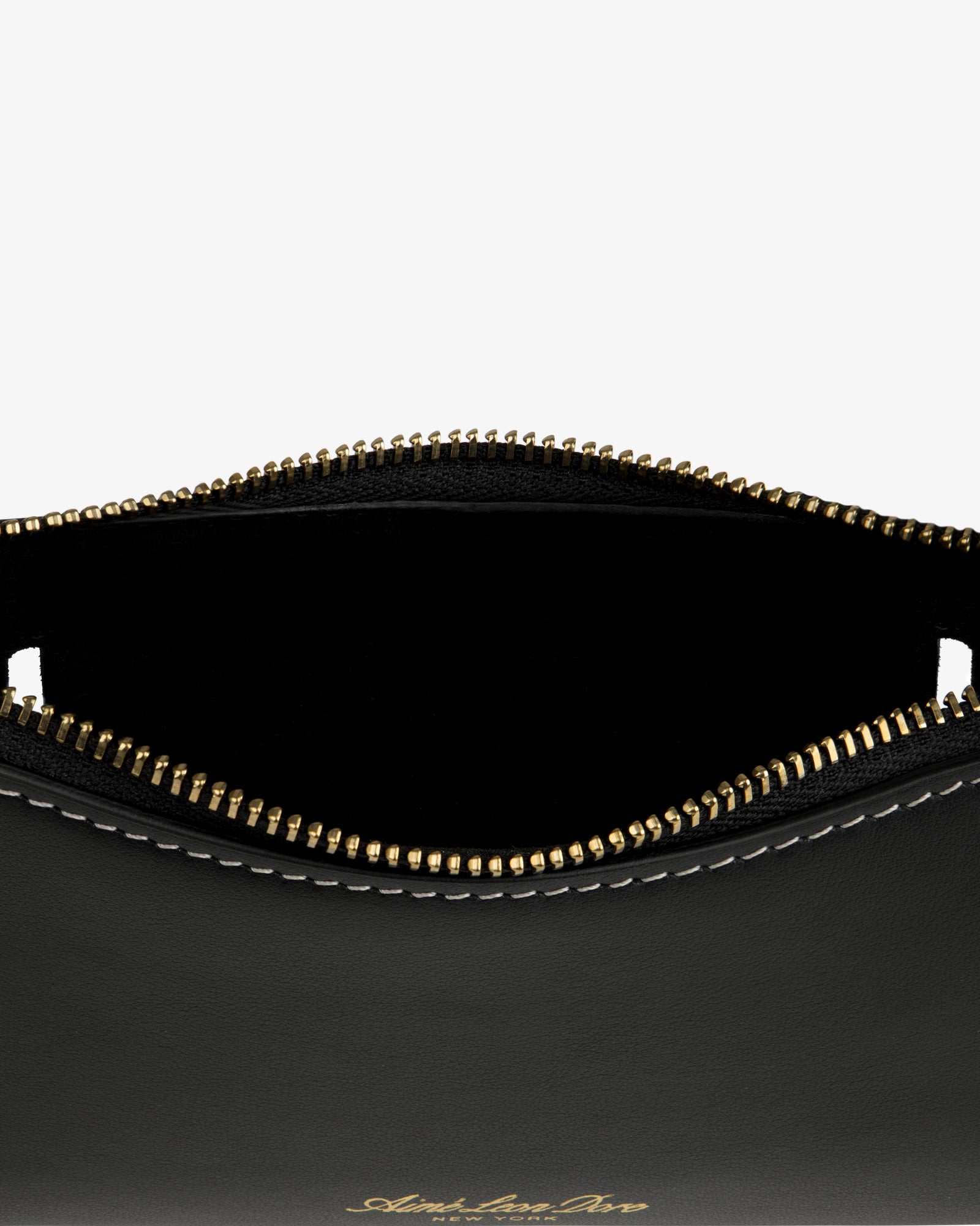 Close-up of the Convertible Leather Belt Bag: open black leather pouch with gold zipper, white stitching, and empty interior.
