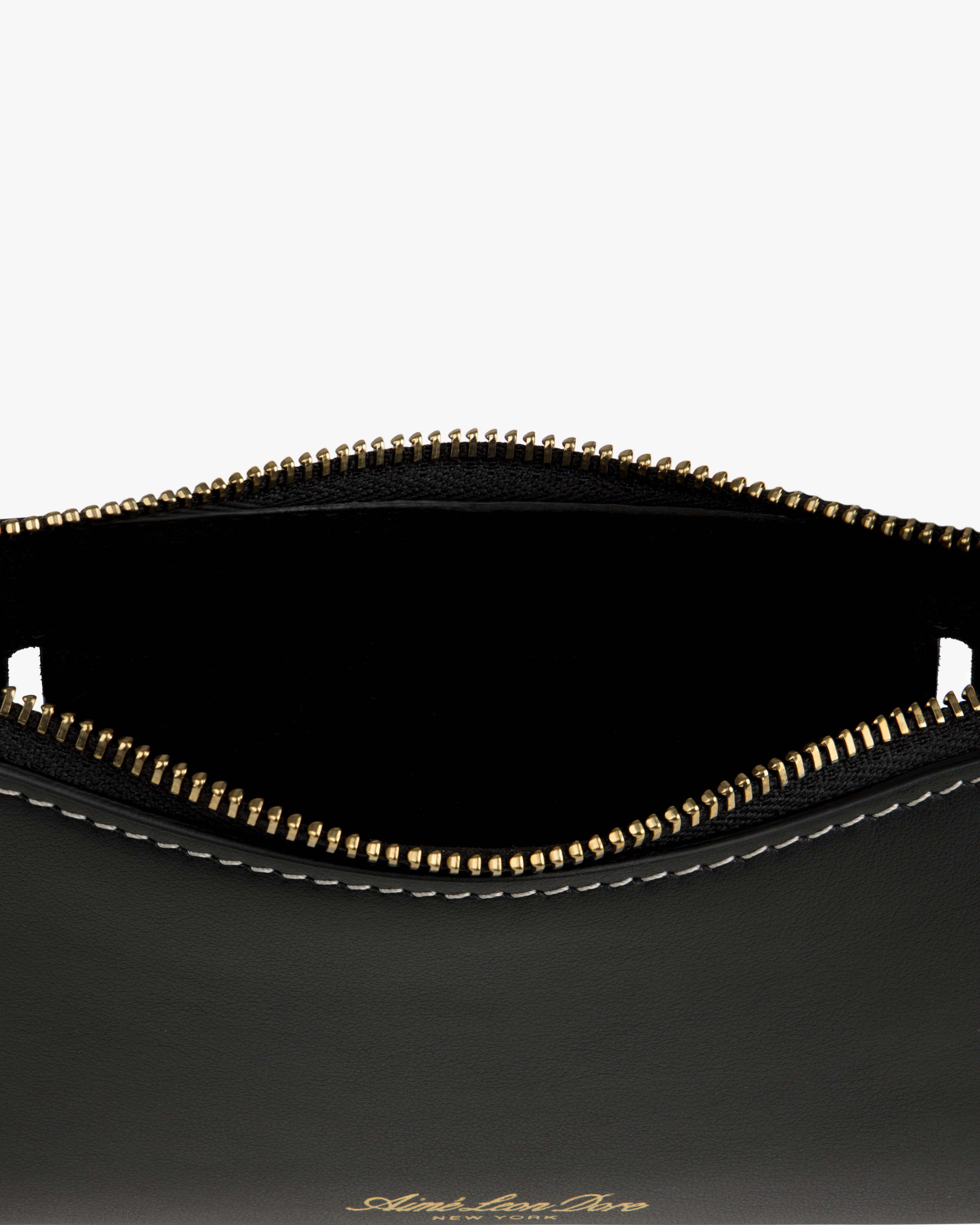 Close-up of the Convertible Leather Belt Bag: open black leather pouch with gold zipper, white stitching, and empty interior.