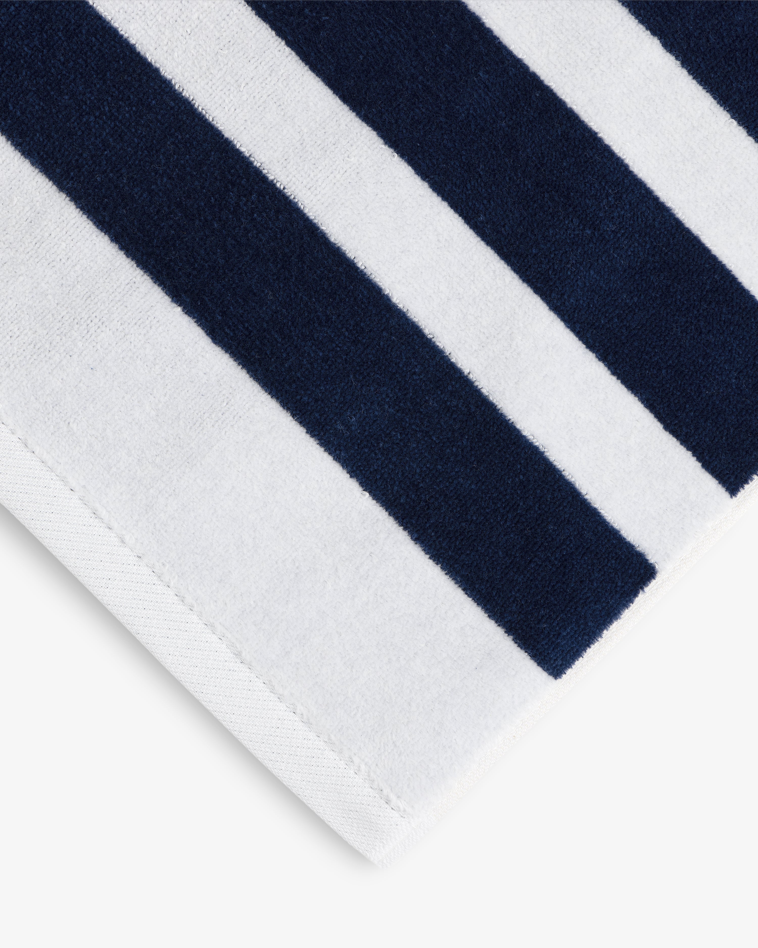A close-up of the Striped Beach Towel featuring thick navy blue and white stripes.