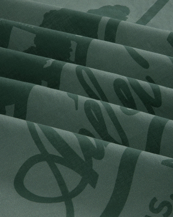 Sun Faded Unisphere Bandana in dark green with shiny cursive script, folded in neat pleats.