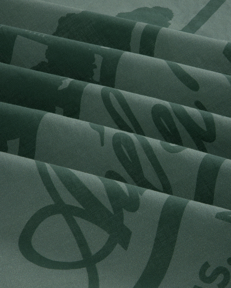 Sun Faded Unisphere Bandana in dark green with shiny cursive script, folded in neat pleats.