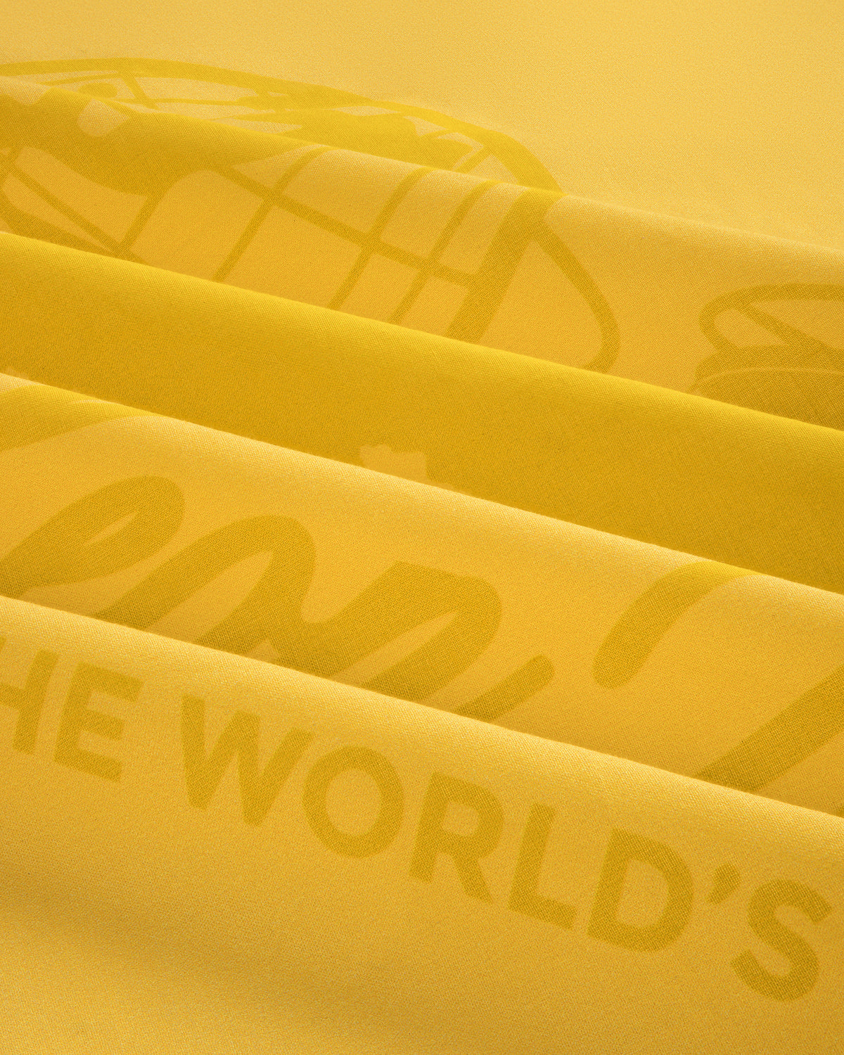 Close-up of the Sun Faded Unisphere Bandana's yellow fabric with layered printed text and graphics.