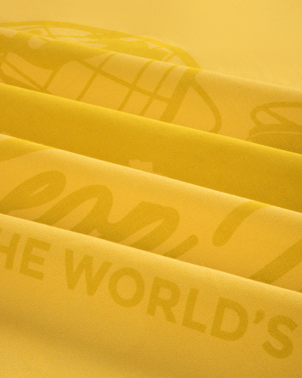 Close-up of the Sun Faded Unisphere Bandana's yellow fabric with layered printed text and graphics.