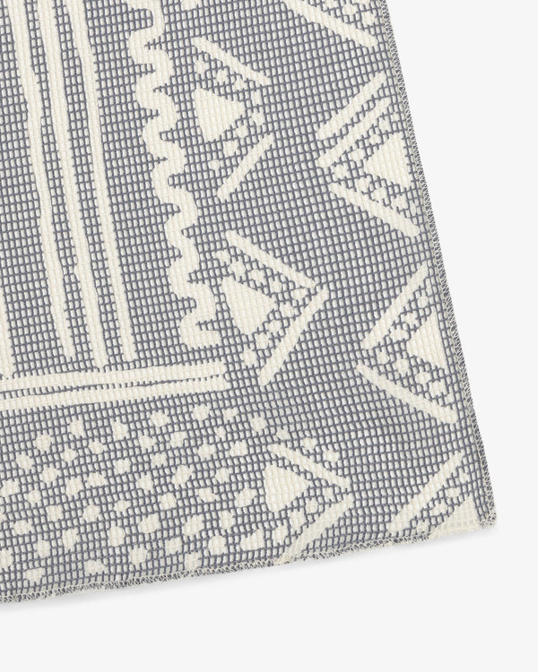 Close-up of Mesh Tapestry Bandana featuring textured gray and white fabric with geometric triangles and rectangles.