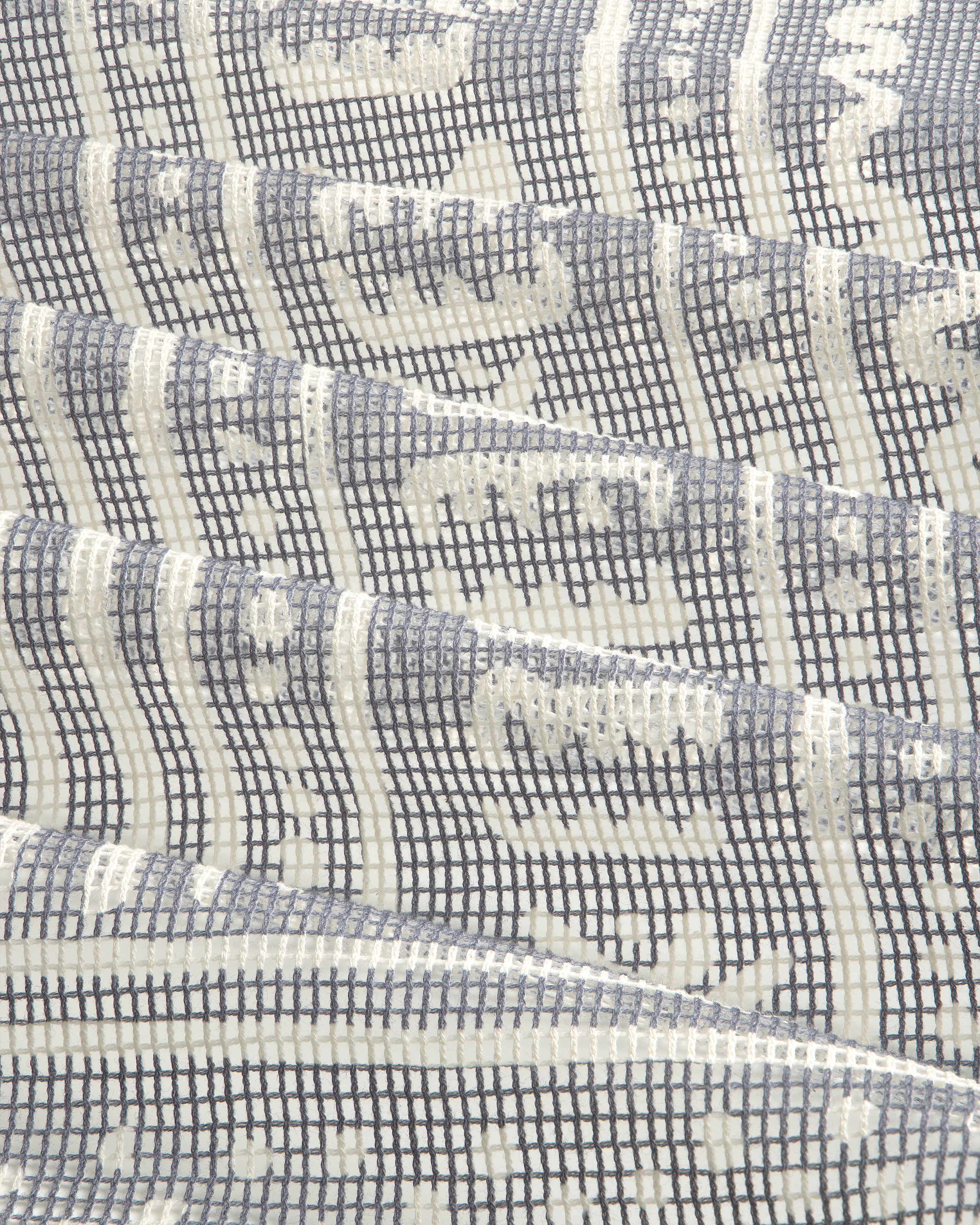 Close-up of the Mesh Tapestry Bandana featuring a geometric grid and wavy white and gray patterns.