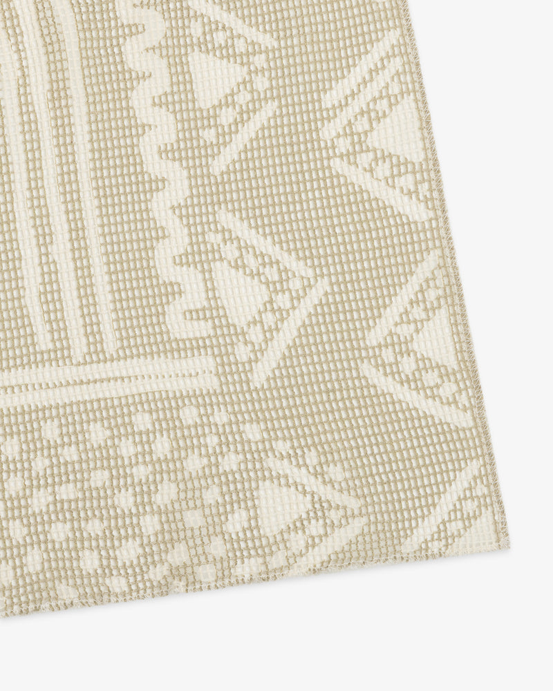 Close-up of a Mesh Tapestry Bandana in beige and white with geometric and zigzag patterns.