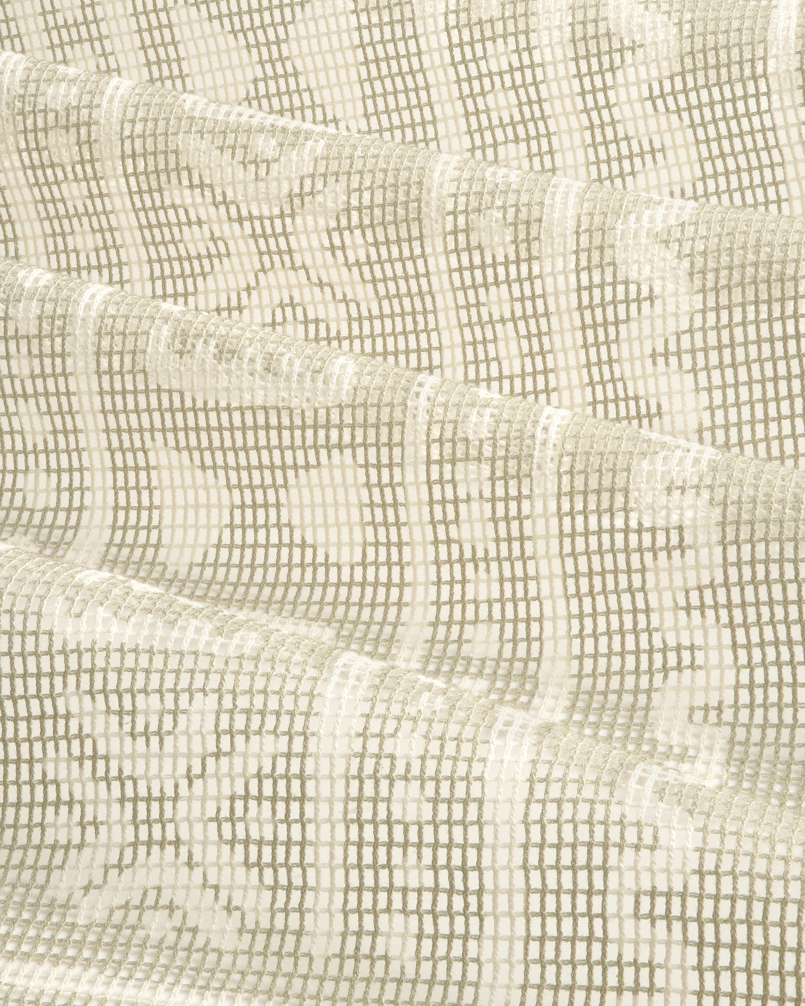 Close-up of the Mesh Tapestry Bandana in cream, showing its textured grid and floral pattern, softly folded.