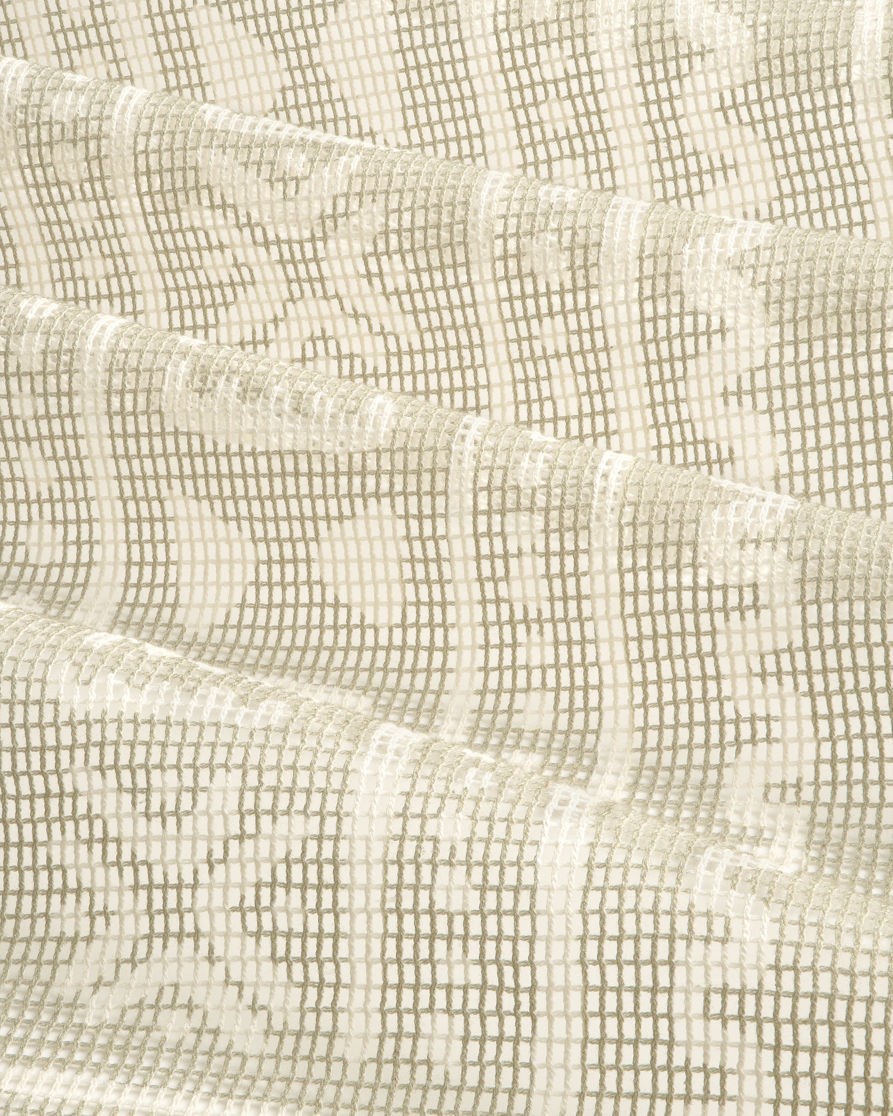 Close-up of the Mesh Tapestry Bandana in cream, showing its textured grid and floral pattern, softly folded.