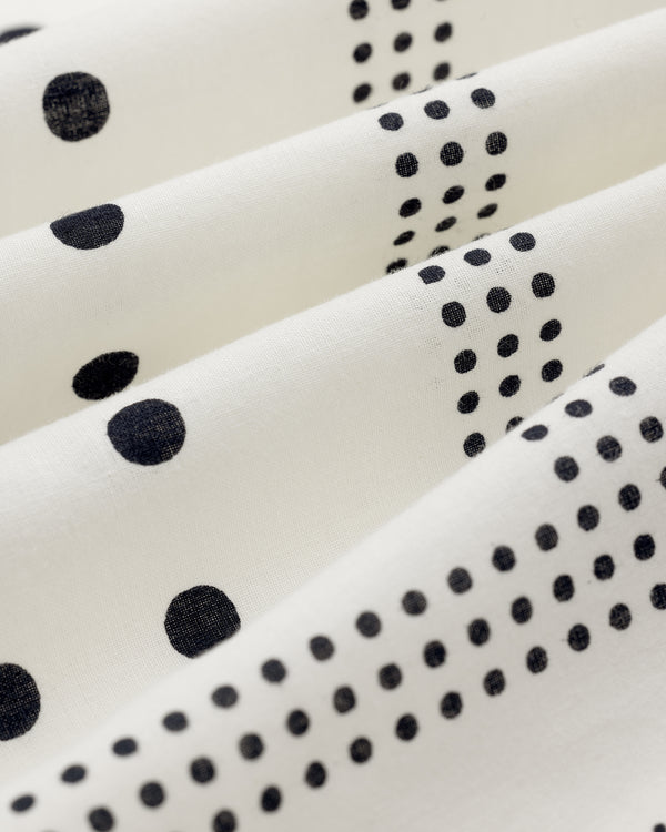 Polka Dot Bandana: White fabric with black dots in varied sizes, draped for soft vertical folds.