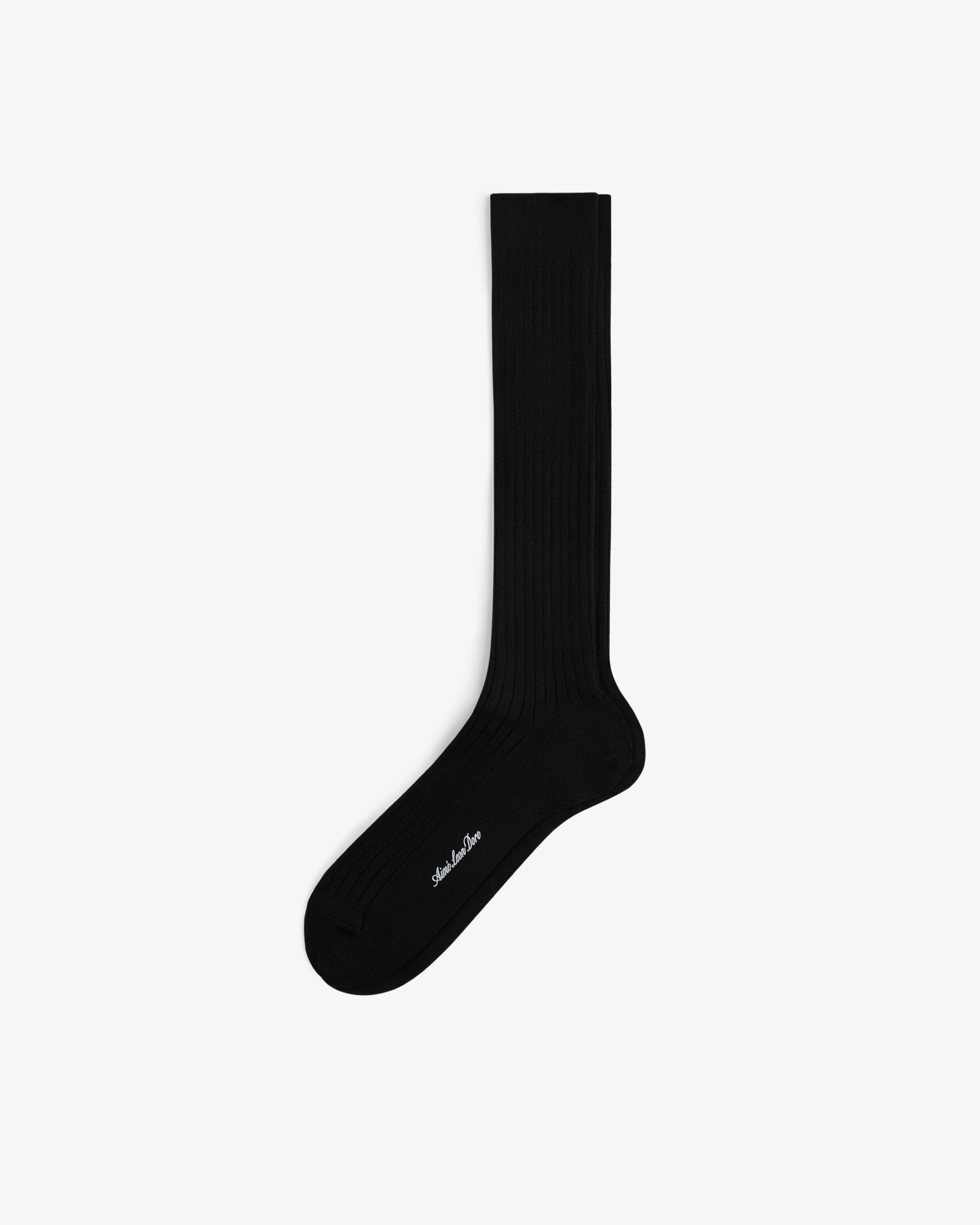 A black Dress Sock with subtle ribbing and small white text near the toe, shown on a white background.
