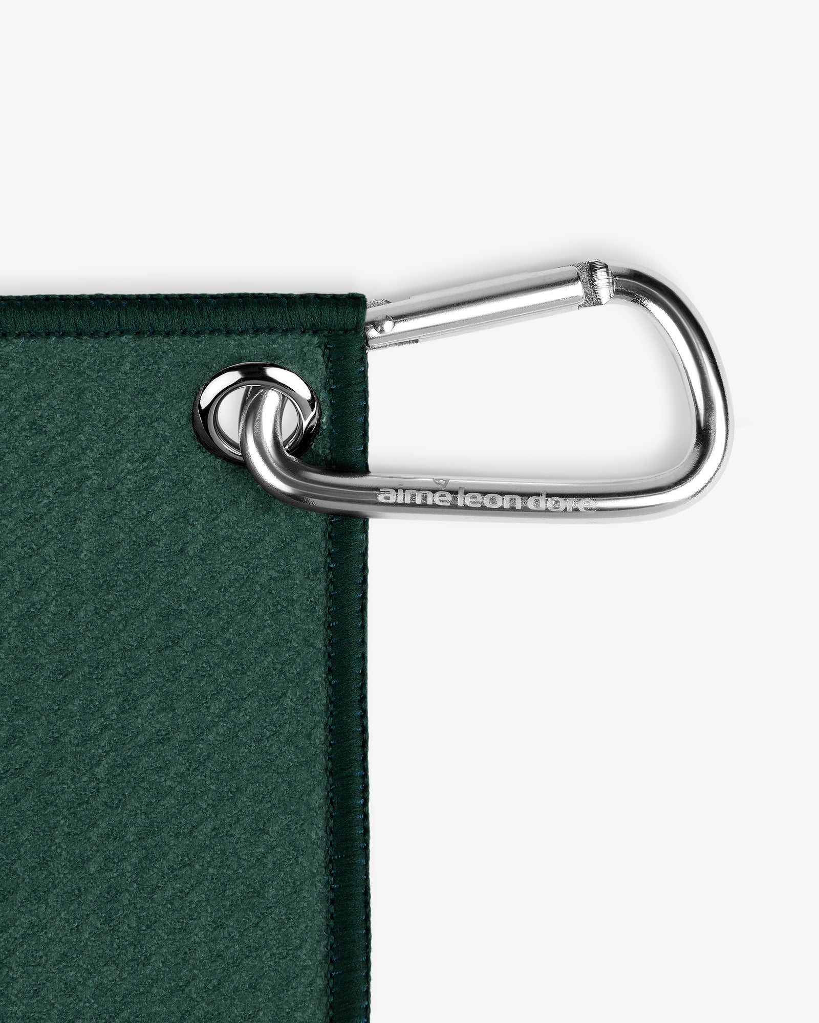 A silver carabiner clips through a metal grommet on the corner of the ALD Golf Caddy Towel.