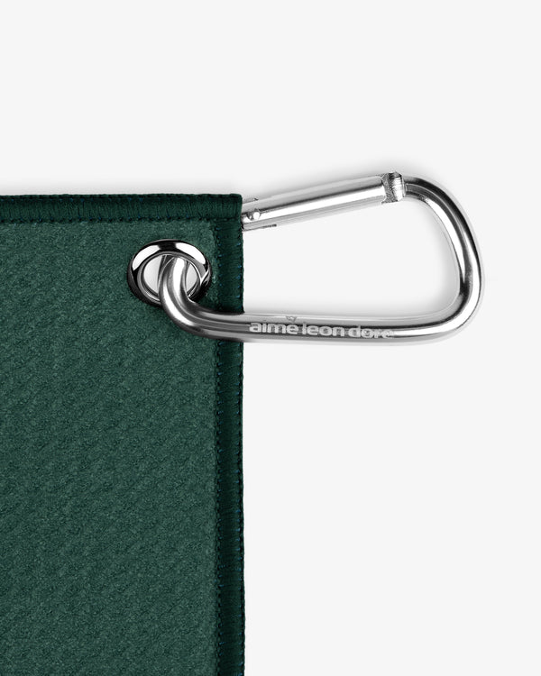A silver carabiner clips through a metal grommet on the corner of the ALD Golf Caddy Towel.