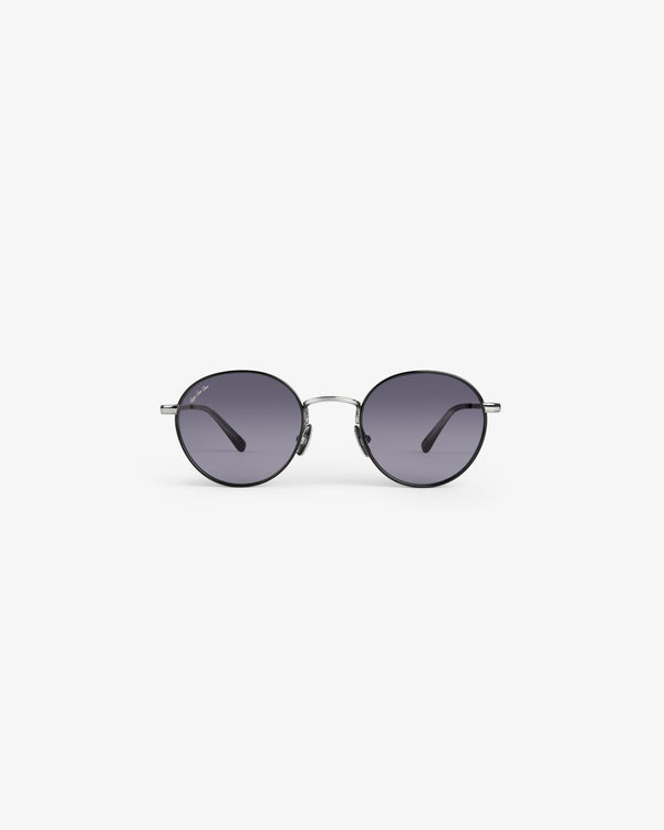 Giórgios Sunglasses: round black lenses, thin metal frame, shown on a white background.