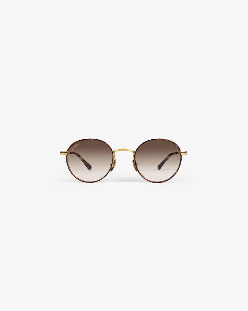 Giórgios Sunglasses: round tortoiseshell frames, brown gradient lenses, gold bridge on a white background.