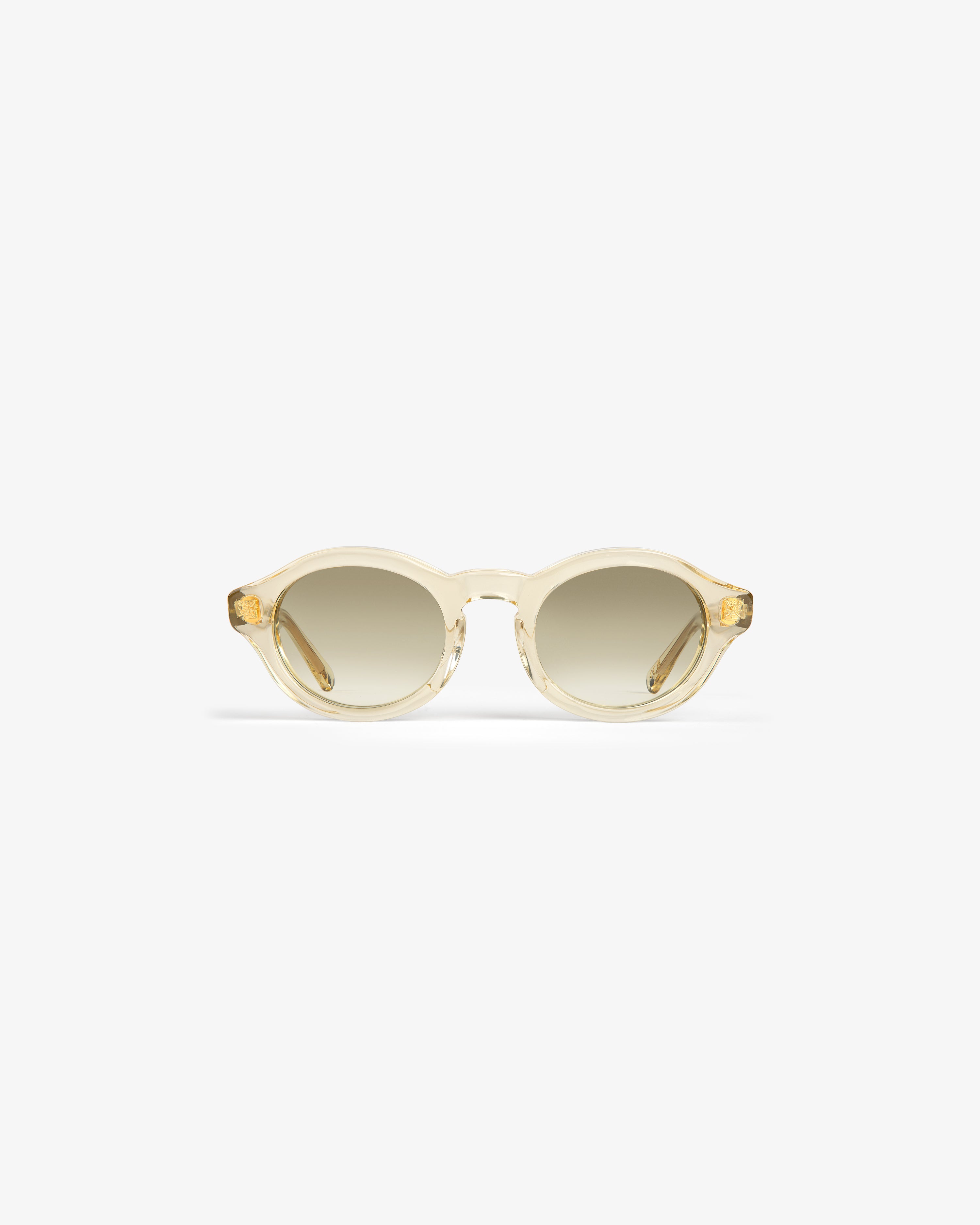 Onásis Sunglasses: Translucent, round light beige frames with gradient tinted lenses on a white background.