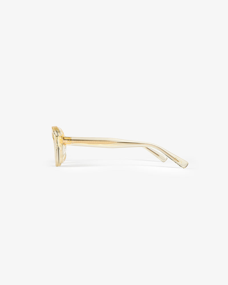 Side view of Onásis Sunglasses, transparent yellow with thick frames and straight arms on a white background.
