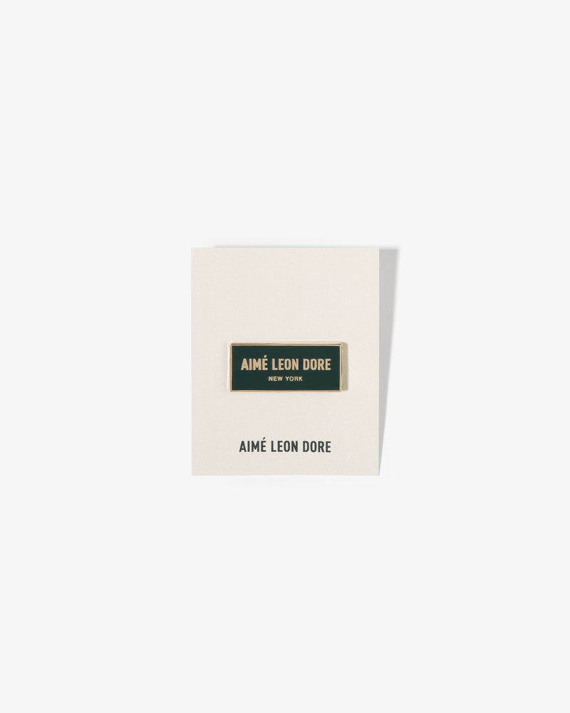 A rectangular Graphic Pin on a white card with the brand’s name printed below.