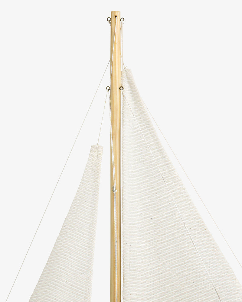 Close-up of the Walnut Model Sailboat’s mast and white sails set against a plain white background.