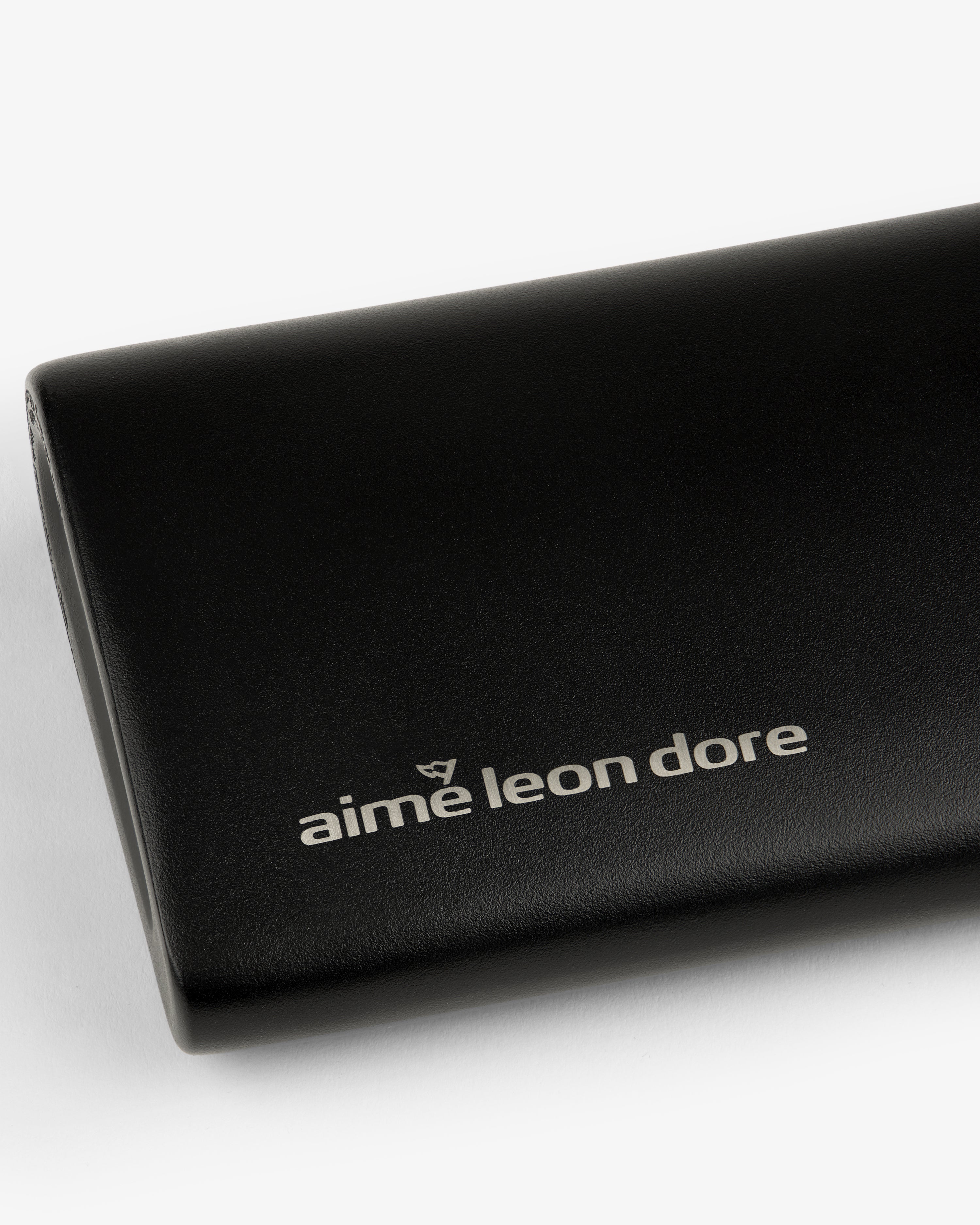 Black leather ALD Golf 19th Flask case featuring the aime leon dore logo in white on the front.