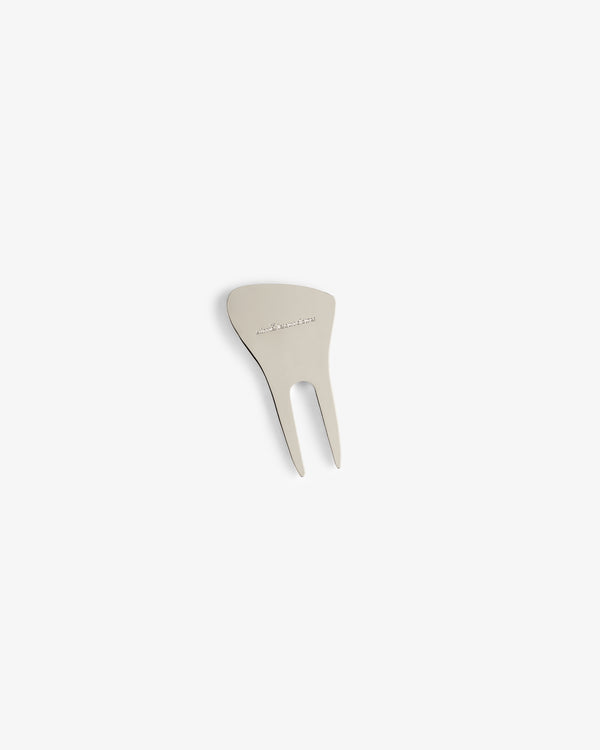 The ALD Golf Divot Tool is a metal, two-prong repair tool with engraved text on its flat top.