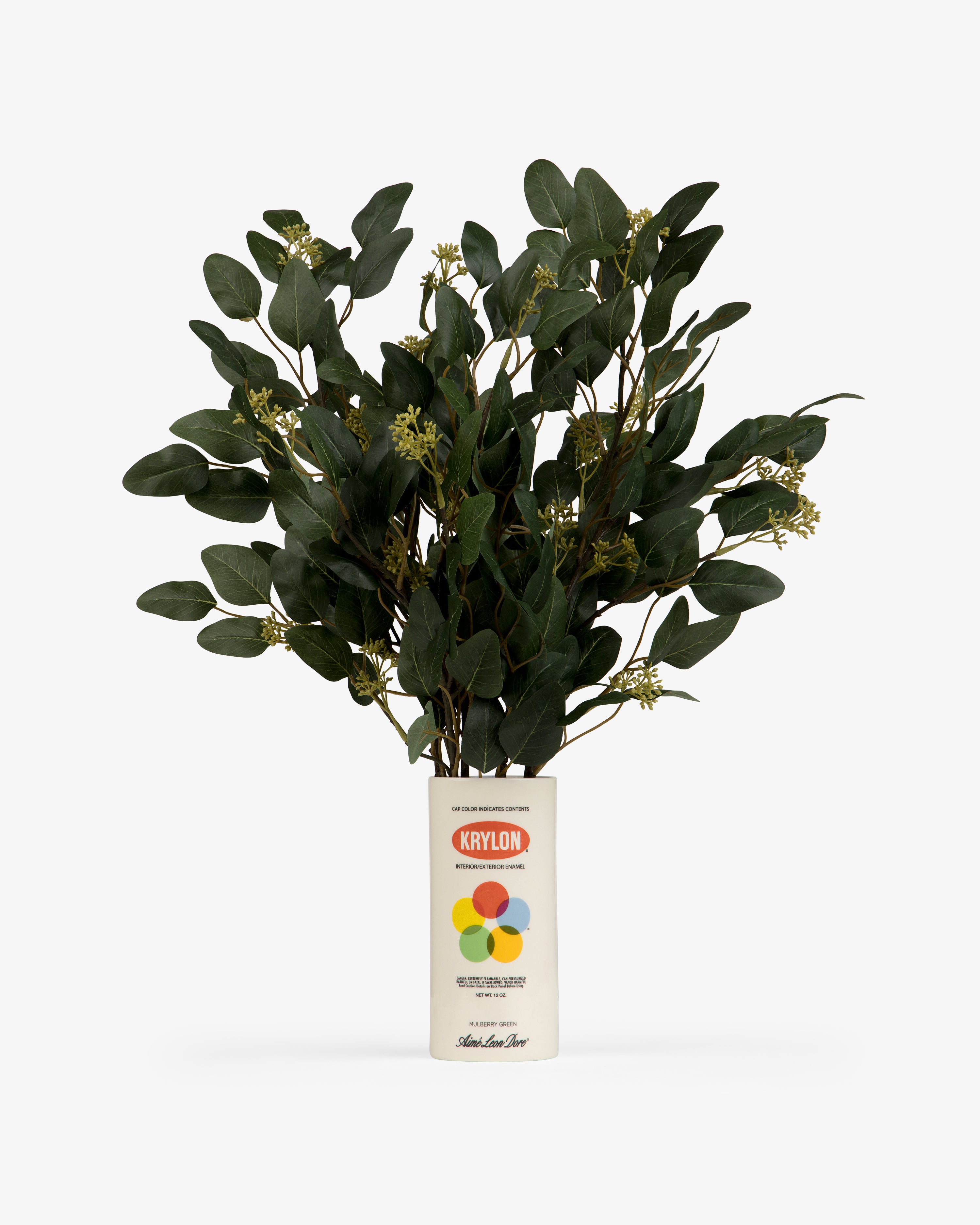 A leafy green plant sits in a Krylon Ceramic Spray Can Vessel, used as a vase, against a white background.