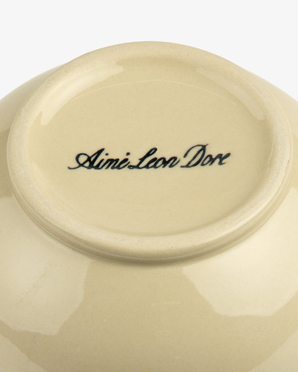 The bottom of a Textile Patterned Vase with Aime Leon Dore written in cursive black lettering.