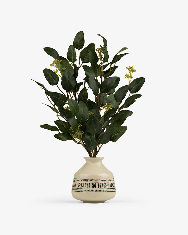 The Textile Patterned Bud Vase displays green leafy branches with small yellow buds.