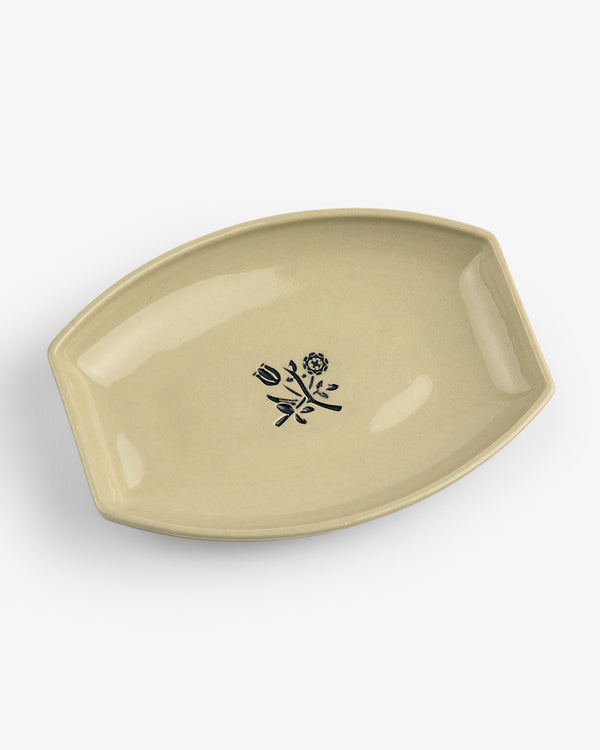 Crest Catchall: Oval beige ceramic dish with two handles and a black floral center design.