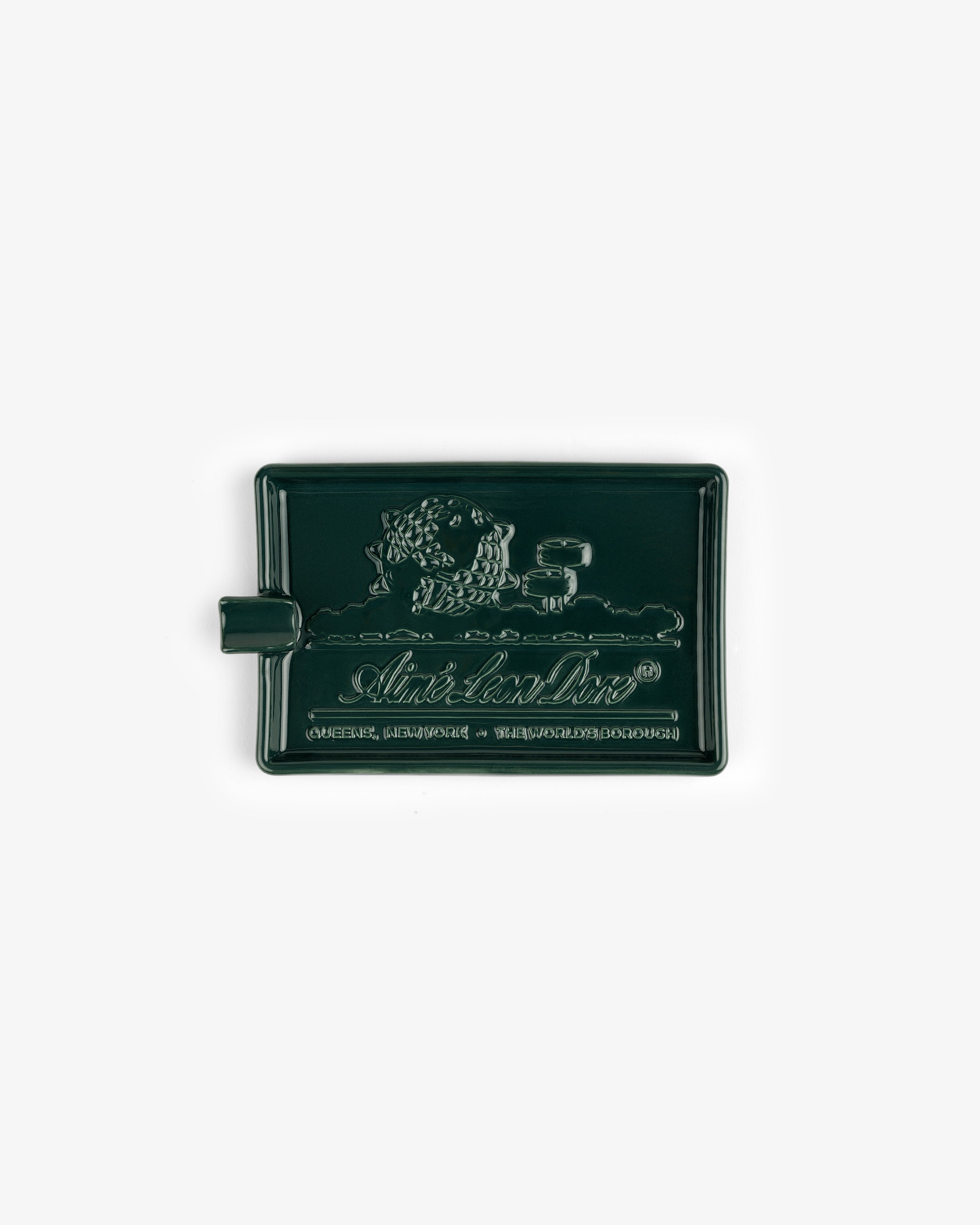 Ceramic Unisphere Ashtray in dark green, rectangular with raised lion design, handle on the left side.