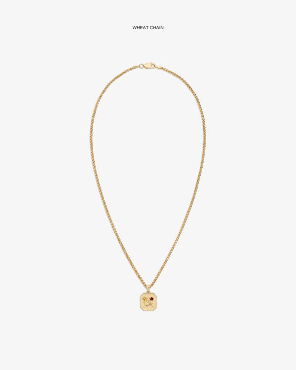 14Kt gold wheat chain necklace with Queens Crest Relief pendant and a small red gem accent.