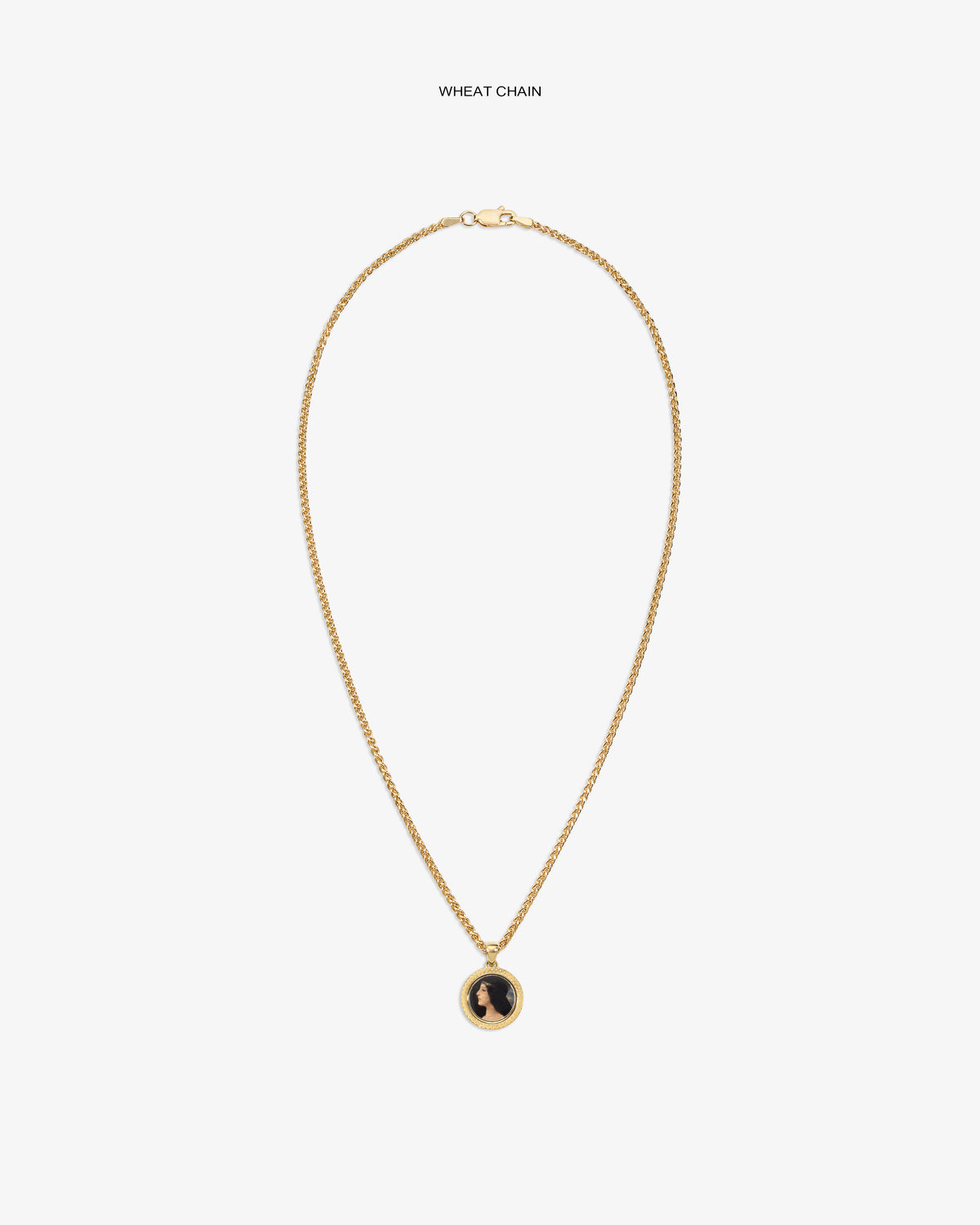 14Kt Gold Hera Pendant on a wheat chain with a black and gold round pendant, shown on a plain white background.