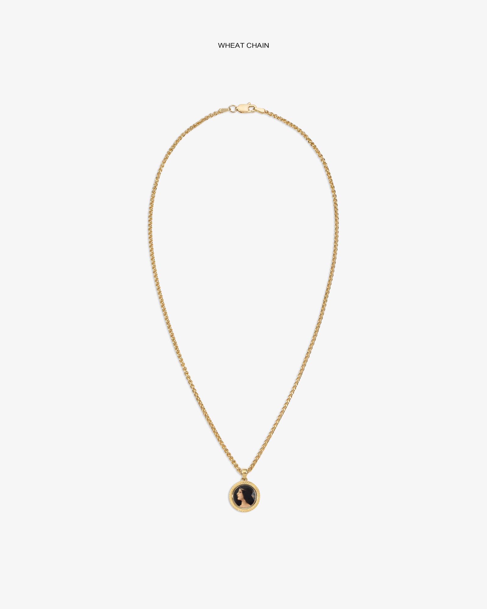 14Kt Gold Hera Pendant on a wheat chain with a black and gold round pendant, shown on a plain white background.