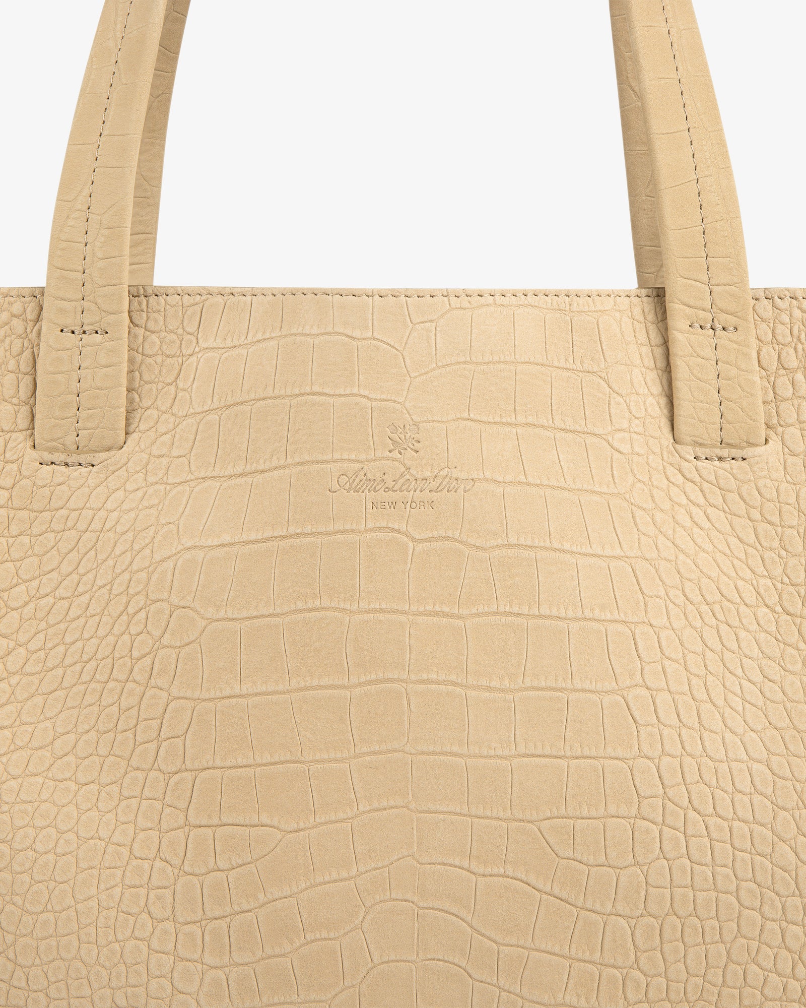 Close-up of the Croc-Embossed Nubuck Tote Bag in beige with two handles and subtle center branding.
