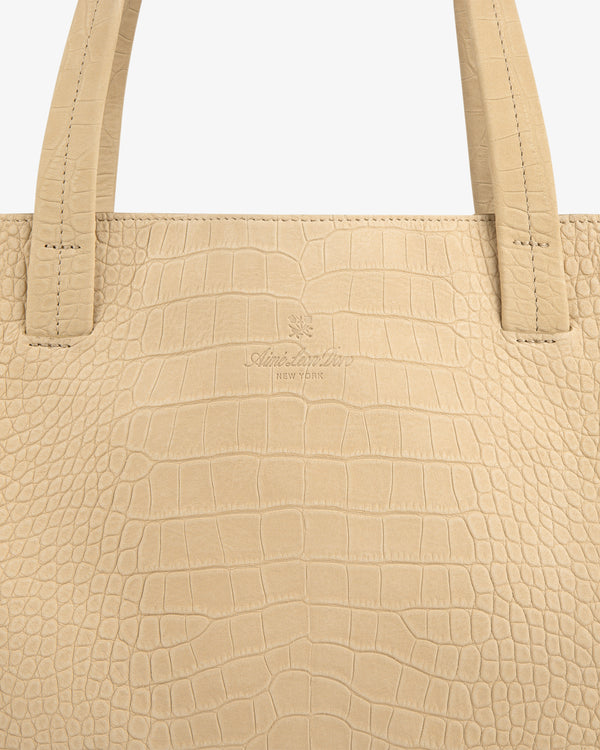 Close-up of the Croc-Embossed Nubuck Tote Bag in beige with two handles and subtle center branding.