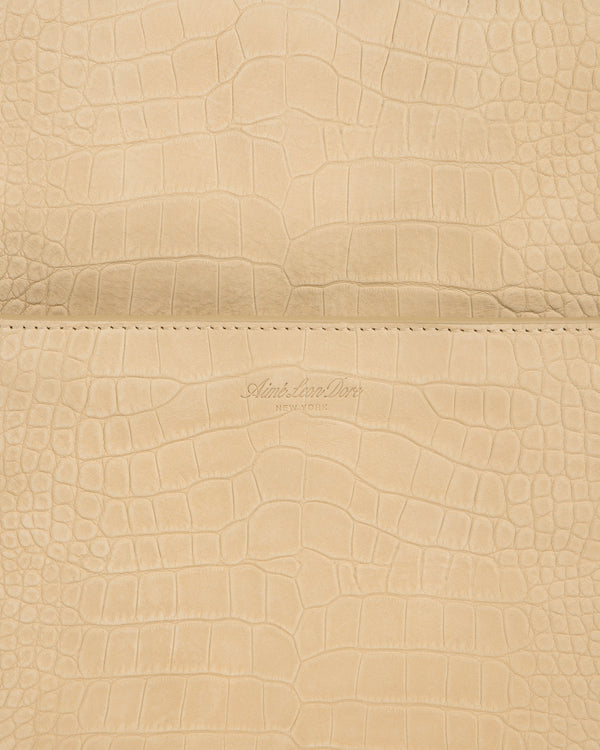 Close-up of beige Croc-Embossed Nubuck Duffle with Aime Leon Dore New York logo debossed at the center.