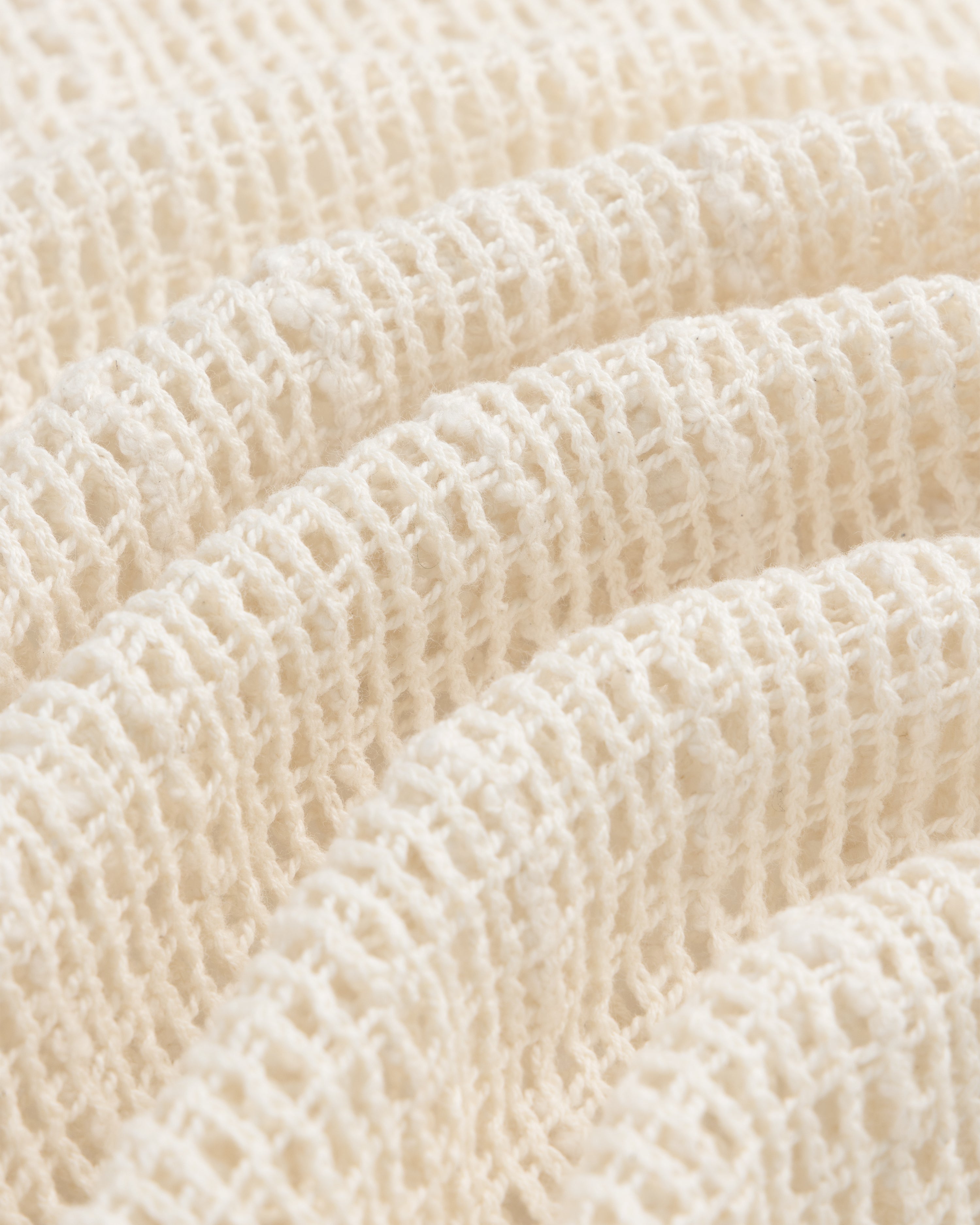 Close-up of the Open Mesh Mini Dress fabric, cream-colored with a soft waffle knit and textured grid pattern.