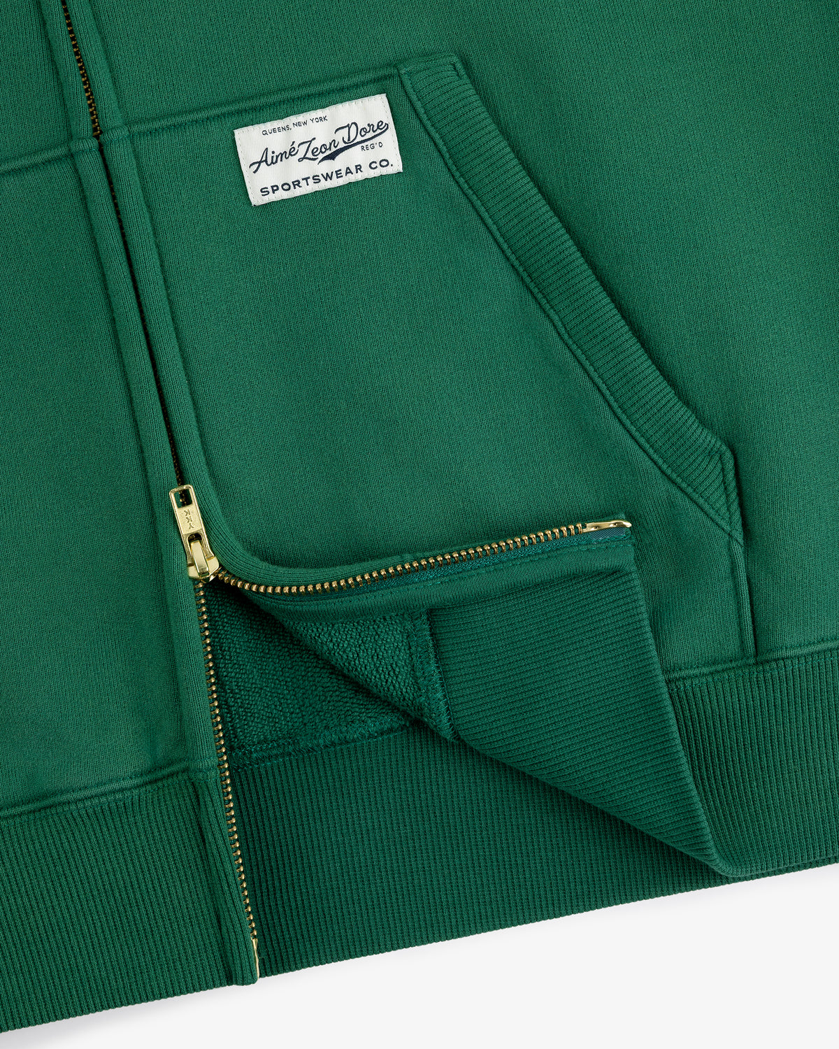 Sun Faded Full-Zip Hoodie in green with front pockets and a white Aimé Leon Dore patch on the left chest.