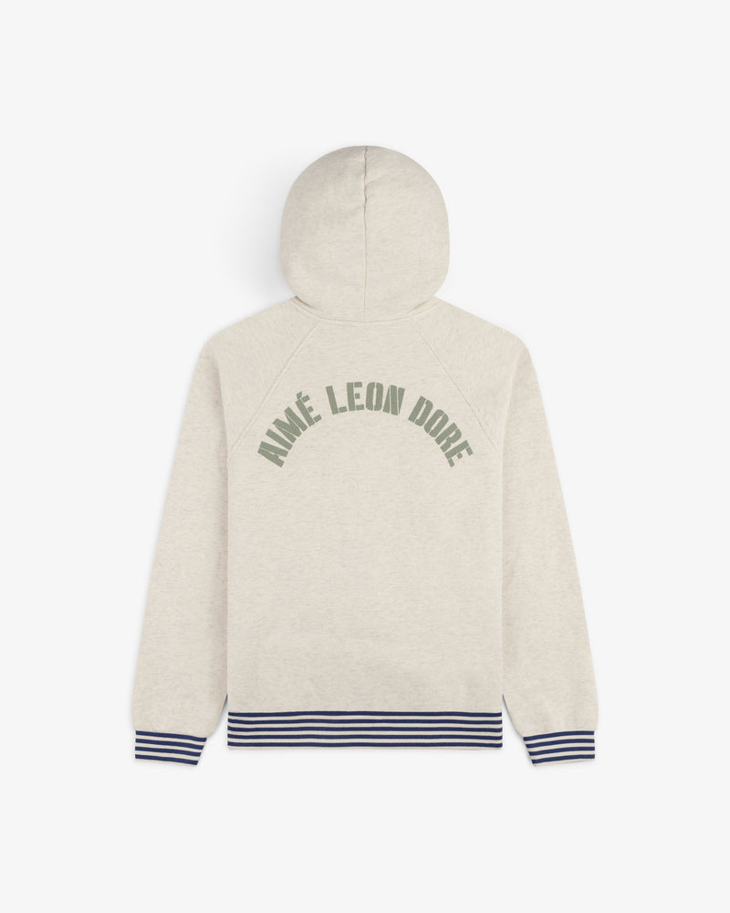 Dock Hoodie: Beige with AIMÉ LEON DORE green text on back, blue-striped cuffs and hem.