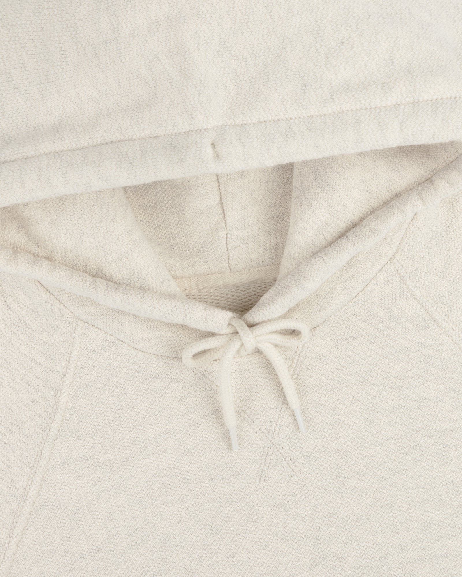 Close-up of the Dock Hoodie in cream, highlighting the hood, drawstrings, and neckline.