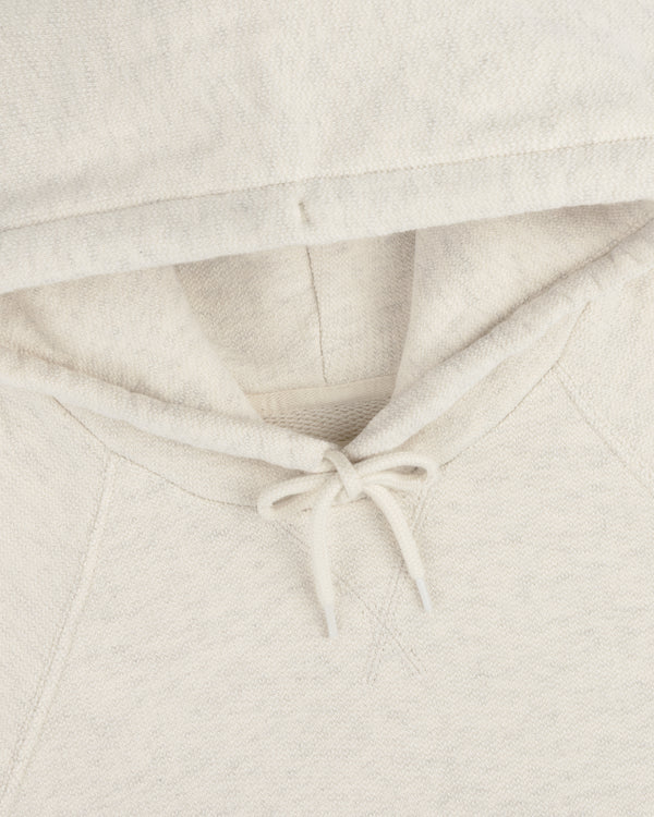 Close-up of the Dock Hoodie in cream, highlighting the hood, drawstrings, and neckline.