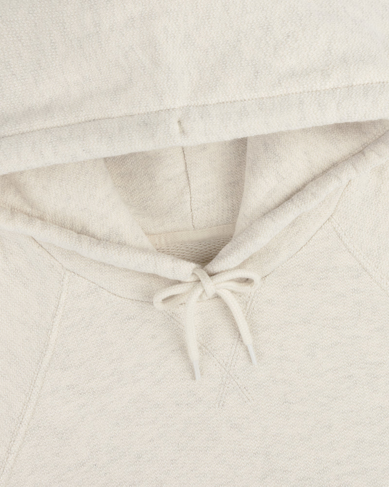 Close-up of the Dock Hoodie in cream, highlighting the hood, drawstrings, and neckline.