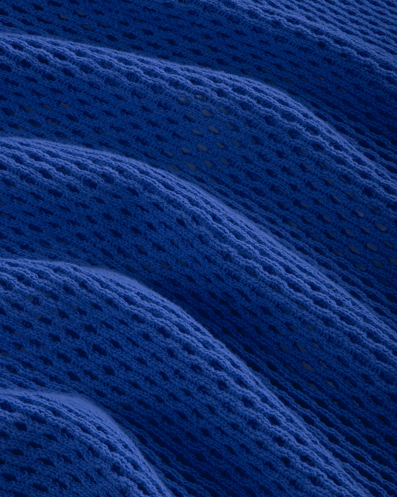 Close-up of Open Mesh Hoodie in blue, showing its textured mesh pattern arranged in soft, wavy folds.