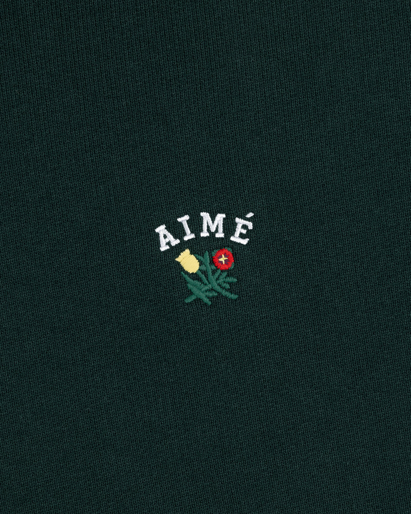 Green Crest Hoodie with AIMÉ embroidered above yellow and red flowers with green leaves.