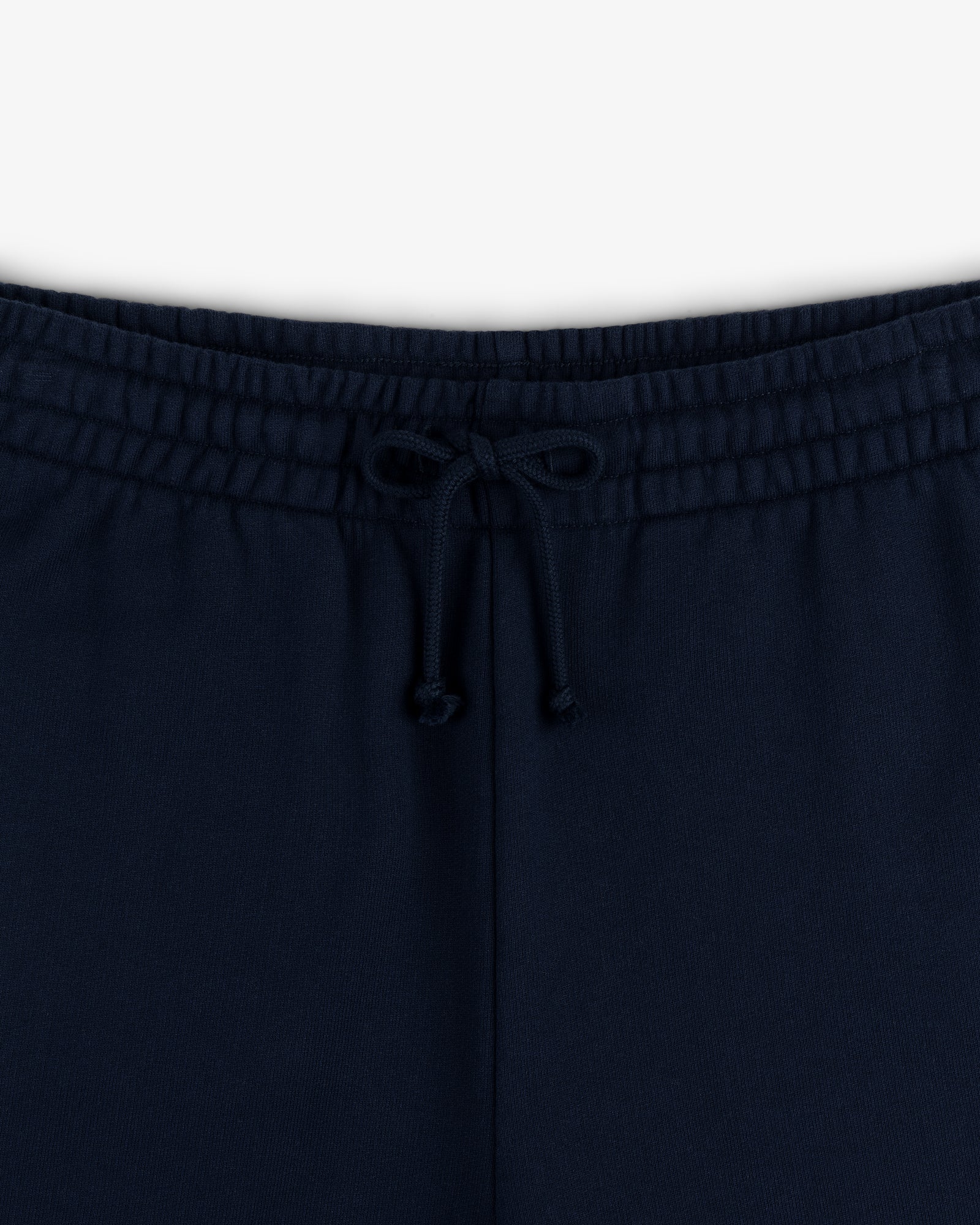 Close-up of the waistband of Crest Sweatpants in navy blue, featuring a front bow-tied drawstring.