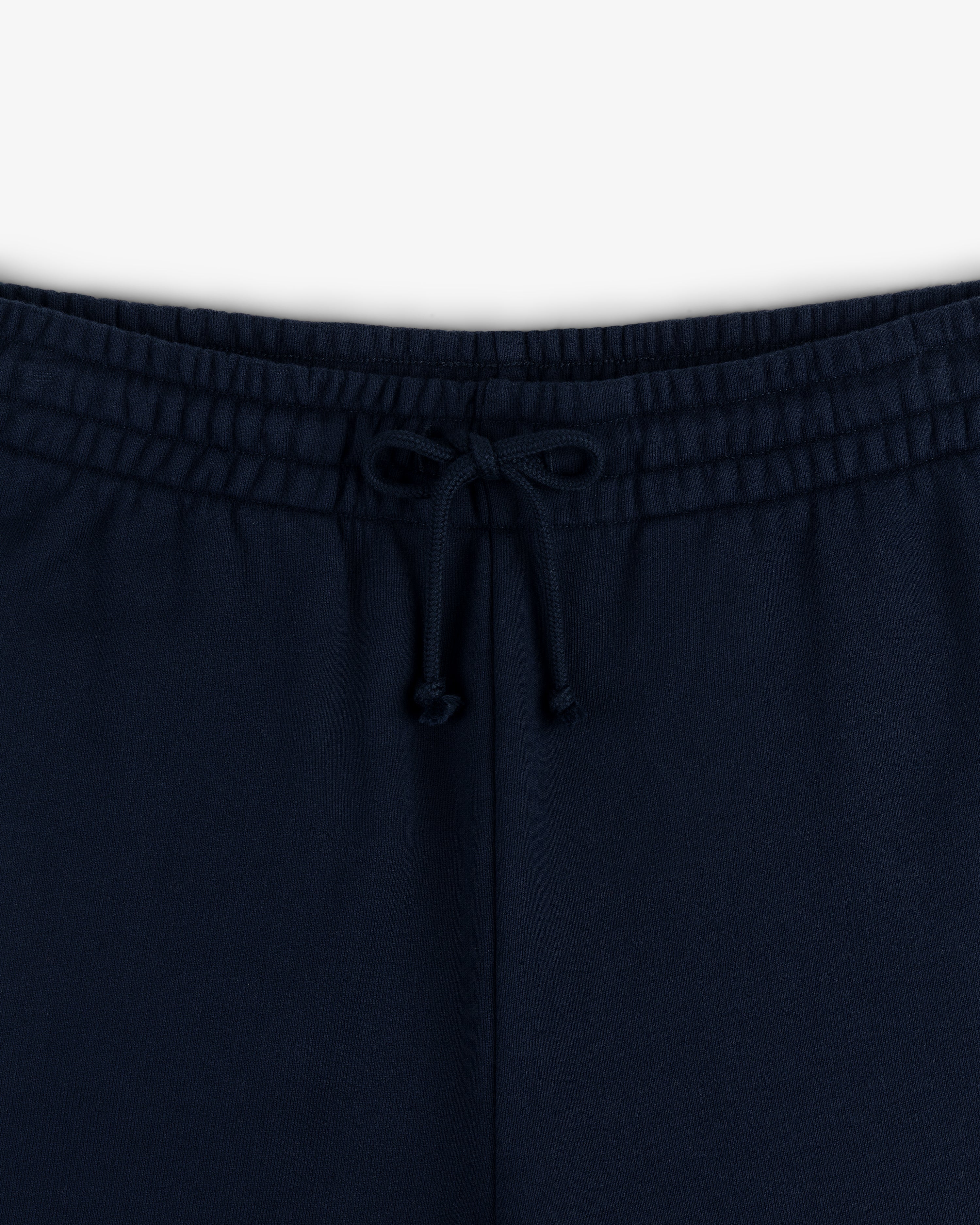 Close-up of the waistband of Crest Sweatpants in navy blue, featuring a front bow-tied drawstring.